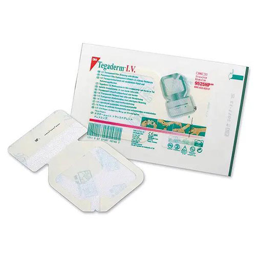 Ein Kanülenfixierverband mit Originalverpackung in weiß, Magenta und grün und vor ihm liegt eines seiner Kanülenfixierverbände ausgepackt auf weißem Hintergrund.jpg